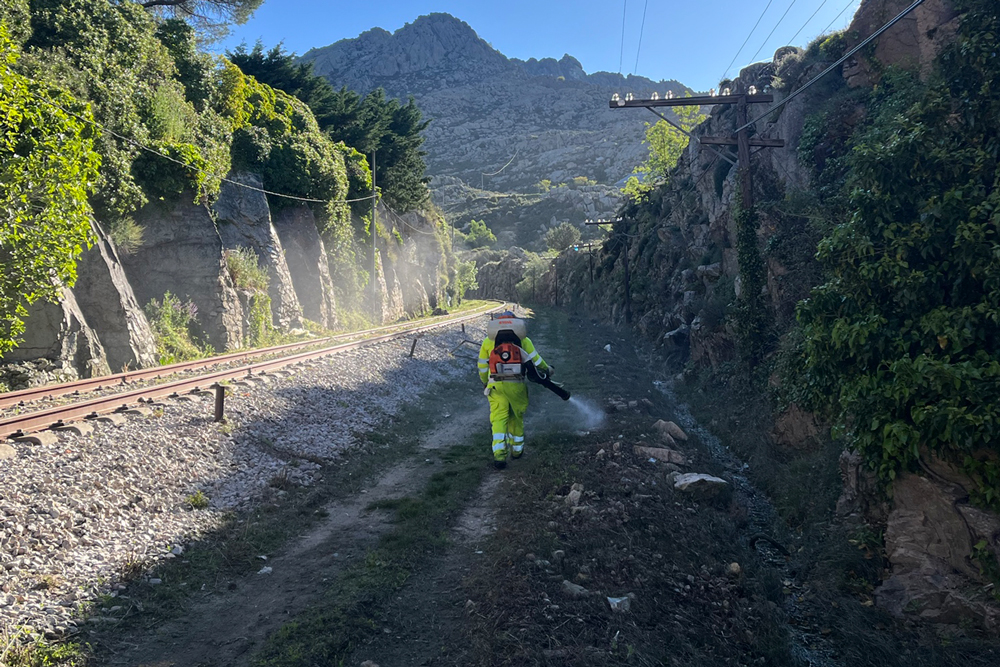 Fumigador con traje en las rieles de tren