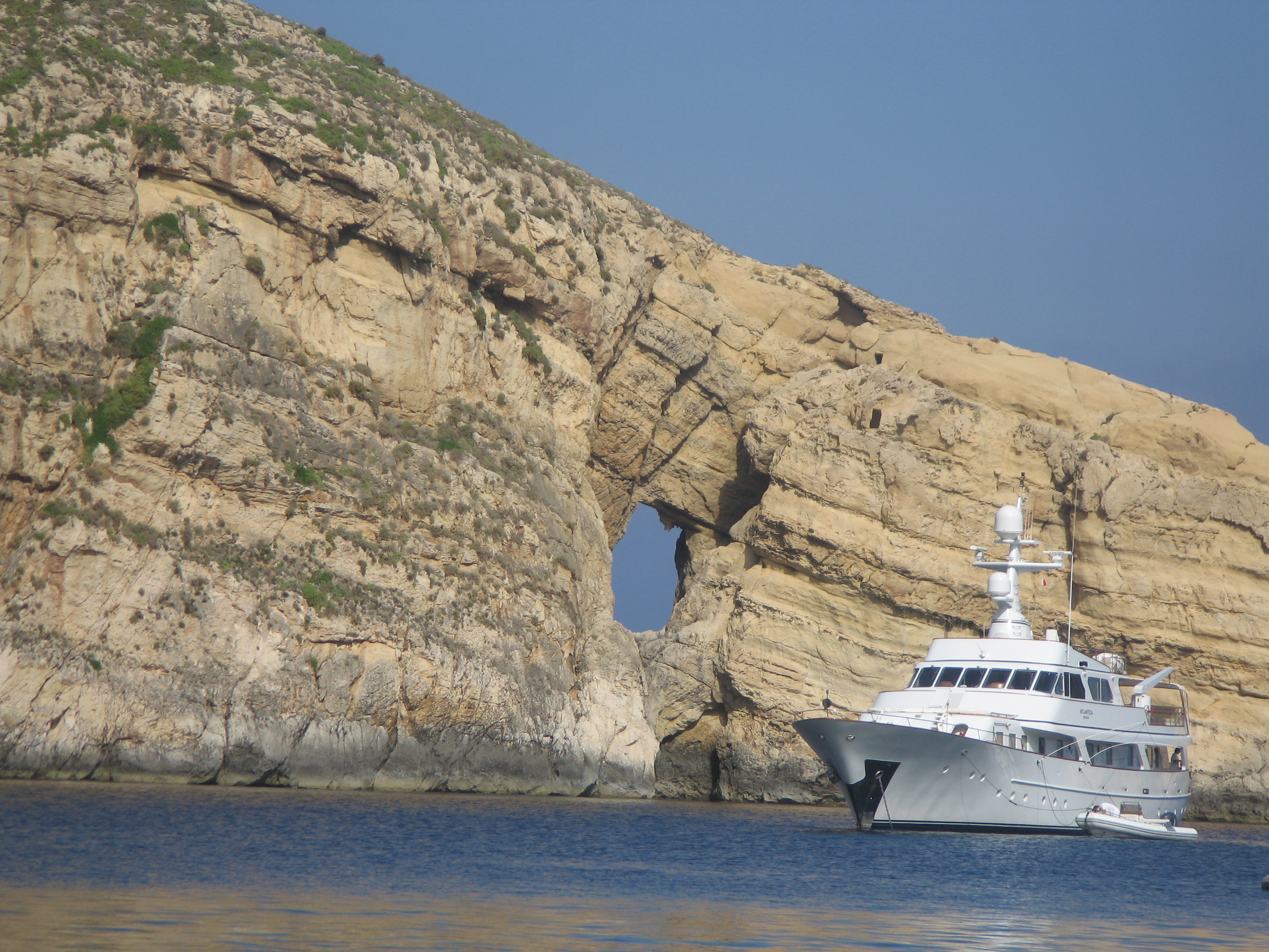Roca del General, islote de la Isla de Gozo, con un barco delante