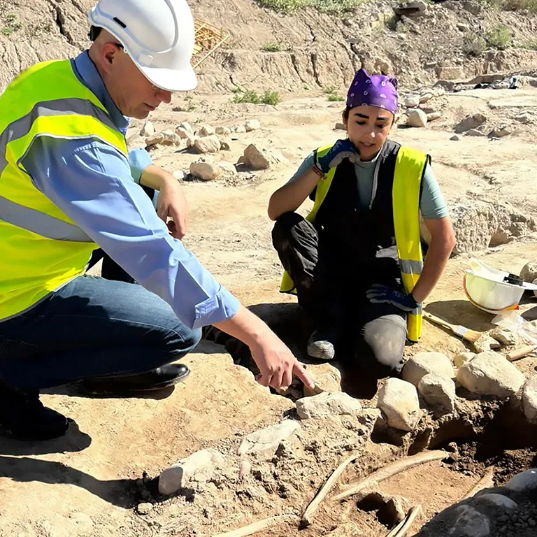 Archaeologists examining a bone site