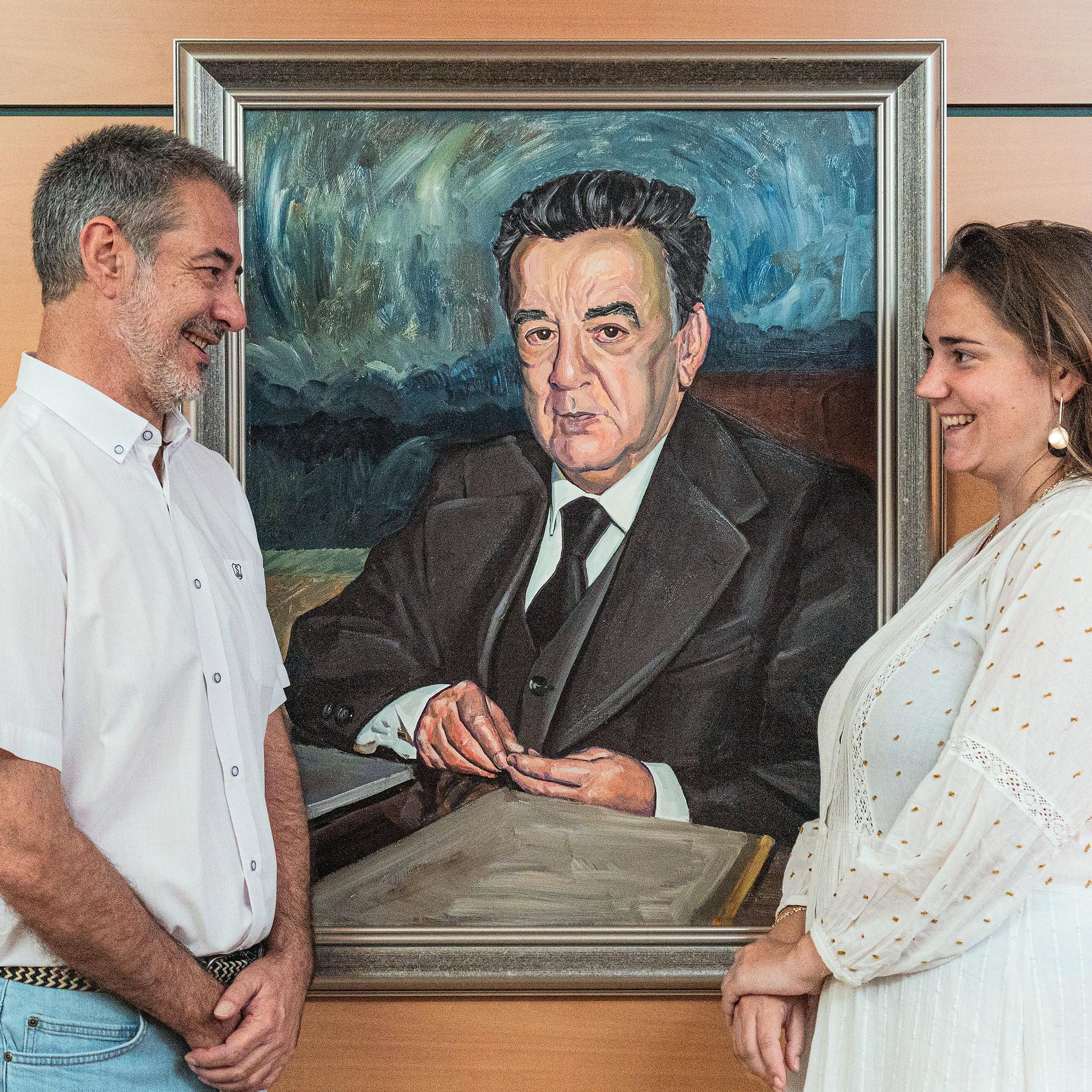 Empleados de Ineco más antiguo y más reciente con retrato del fundador, Carlos Roa.